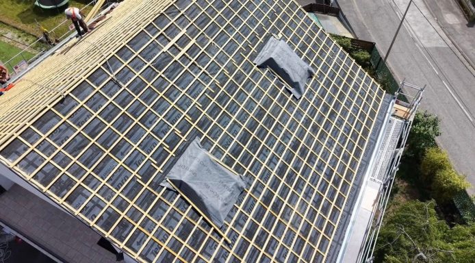 Toit avec panneaux solaires, lucarnes et toiture en tuiles. Vue plongeante.